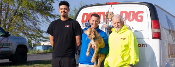 Dirty dog employees in front of work van
